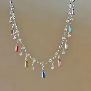 Close-up of elegant silver necklace with vibrant multi-colored baguette-cut stone charms