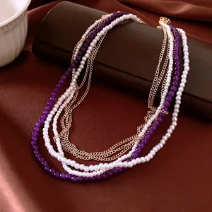 Elegante collana a più strati con perle bianche, perline viola e catene dorate