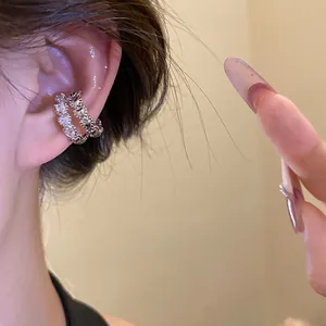 Macro view of a silver double-layered ear cuff with sparkling cubic zirconia on a model
