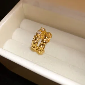 Macro view of a golden heart-shaped double ear cuff with sparkling zircon accents.