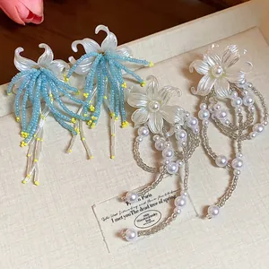 Close-up detail of elegant French style flower tassel earrings with pearls and beads