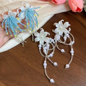 Elegant detailed view of handmade floral tassel earrings with blue beads and white pearls