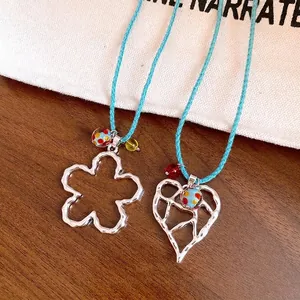 Squisita collana con ciondolo a cuore e fiore traforato in argento con cordino blu