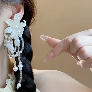 Detailed close-up view of elegant white flower stud earrings with cascading pearl tassels