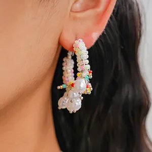 Detailed view of colorful beaded hoop earrings with multiple white dangling pearls