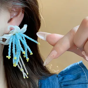 Close-up detail of elegant light blue beaded floral fringe earrings for a vacation style look