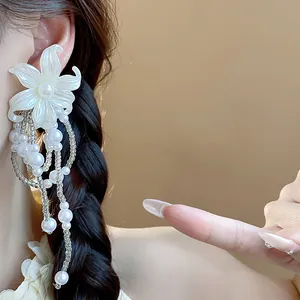 Elegant French style flower earrings with pearl tassels shown as worn detail view