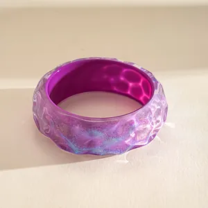 Close-up macro view of a vibrant purple marbled resin bangle with a unique rippled texture.