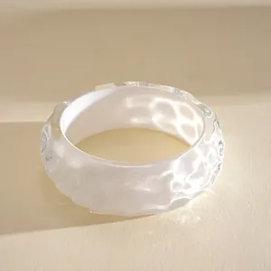 Detailed view of iridescent resin bangle with ripple texture and opalescent finish