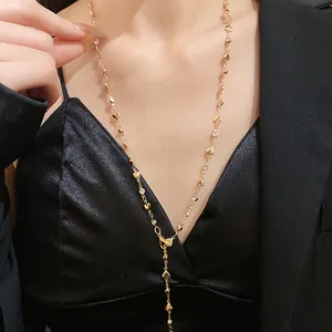 Dettaglio ravvicinato di una collana a Y con cuore dorato e strass su modella