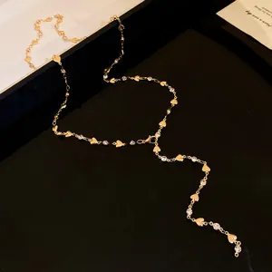 Dettaglio della collana a Y dorata con ciondoli a cuore e strass brillanti lussuosi