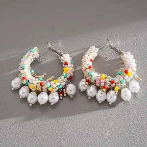 Detailed view of colorful beaded hoop earrings with elegant hanging white pearls