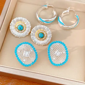 Detail view of silver earrings set featuring turquoise beads and sparkling zircon stones