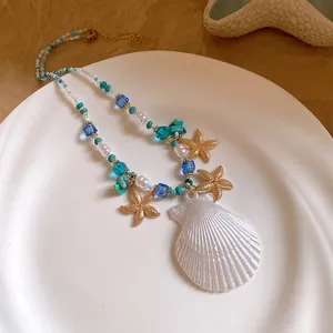 Macro view of ocean-themed necklace featuring golden starfish and large shell pendant