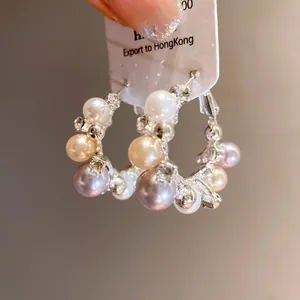 Macro detail of elegant hoop earrings decorated with multi-colored pearls and rhinestones