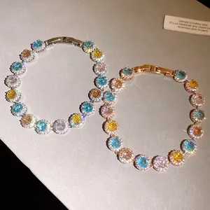 Primo piano di braccialetti con zirconi multicolore scintillanti in oro rosa e argento