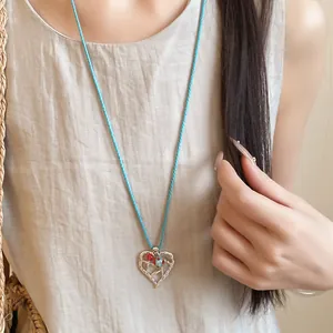 Primo piano dettagliato di una collana con ciondolo a cuore traforato in argento