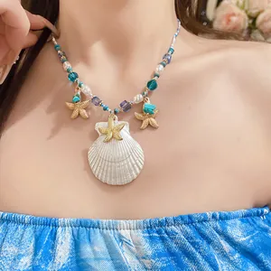 Detail of a beach vacation necklace with shell and starfish charms on a model.
