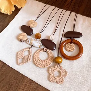 Vintage ethnic style long necklaces with irregular woven and wooden pendants on a canvas bag.