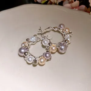 Detailed view of silver hoop earrings featuring multi-colored pearls and crystal accents