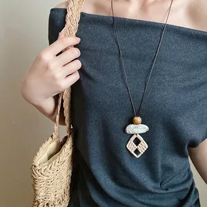 Retro long ethnic style necklace with irregular geometric stone and woven pendant.
