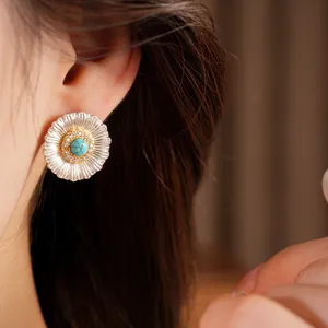 Close-up detail of silver needle sun flower stud earring with turquoise and zircons
