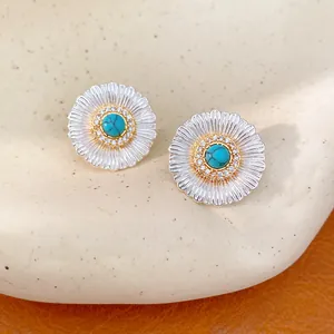 Close-up detail of silver floral stud earrings with turquoise stones and zircon accents