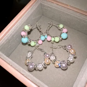 Detailed macro shot of elegant rhinestone pearl hoop earrings displayed in a gift box