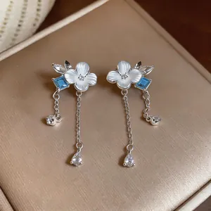 Elegantes pendientes largos de plata con flores de nácar y detalles de circón azul