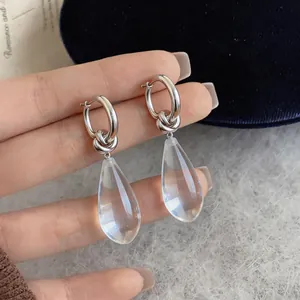 Detailed macro view of elegant silver needle resin teardrop earrings featuring a stylish knot design