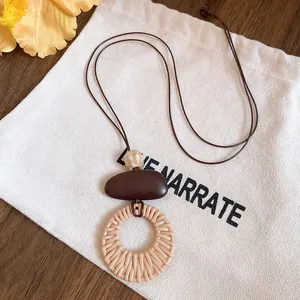 Detail of ethnic style long necklace with woven circular pendant and resin beads