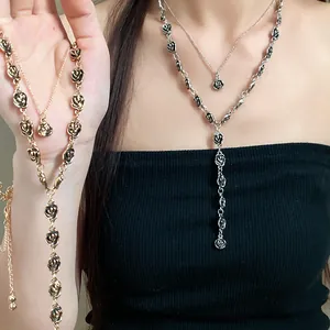 Primo piano di collane a doppio strato con rose vintage in metallo oro e argento
