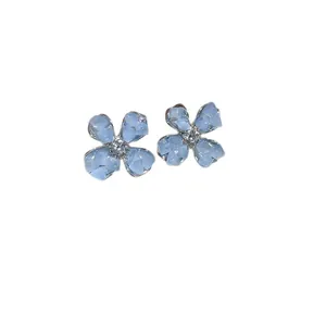 Elegant light blue crushed stone flower stud earrings with central zircon accent