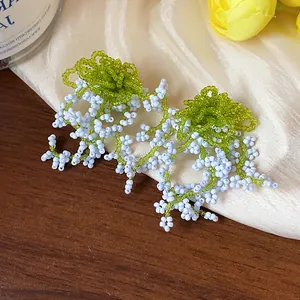 Macro detail of French pastoral style glass beaded tassel earrings with silver needles