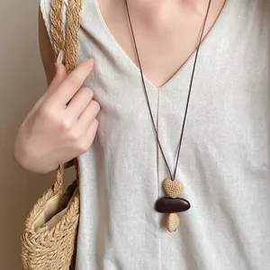 Close-up detail of a vintage long necklace featuring irregular textured stone pendants
