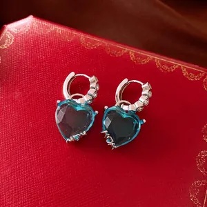 Elegant vintage heart-shaped blue zircon hoop earrings on a luxury red jewelry box