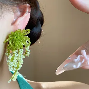 Detailed view of French pastoral style glass beaded tassel earrings on model ear