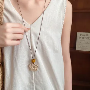 Close-up of retro woven flower pendant on an adjustable ethnic style long sweater chain