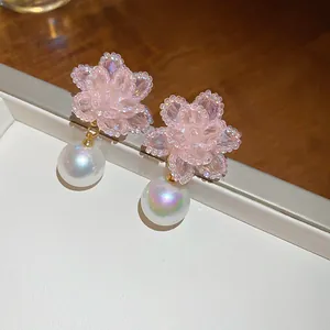 Primo piano di orecchini a fiore di cristallo rosa con perle iridescenti
