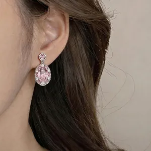 Vintage-Ohrhänger aus Silber mit ovalem rosa Zirkon am Ohr des Modells