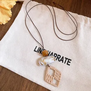 Detail view of ethnic long necklace with marble resin bead and woven diamond pendant