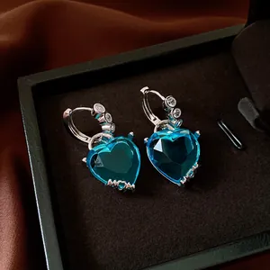Close-up detail of vintage heart-shaped blue zircon hoop earrings with MOM engraving