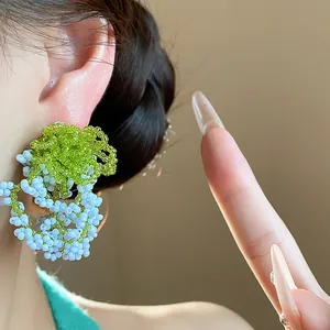 Close-up of French pastoral style green and blue glass beaded stud earrings for women