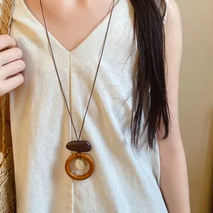 Close-up of a vintage ethnic style wooden pendant necklace with an adjustable cord