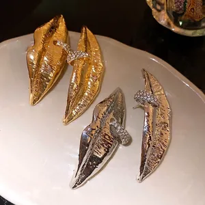 Vintage lip-shaped drop earrings with rhinestone accents in gold and silver finish