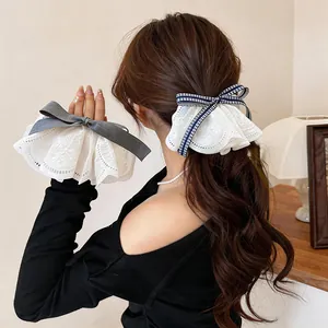 Detailed view of an elegant lace bow hair clip with intricate floral embroidery