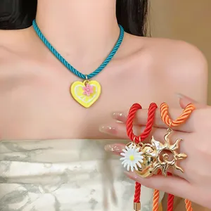 Detail shot of colorful dopamine cord necklaces with heart, daisy and sun charms.