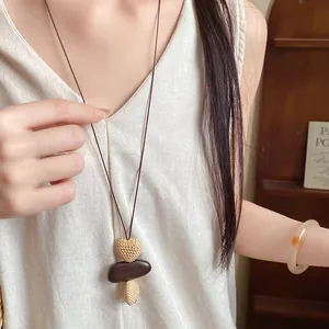 Detailed view of a vintage ethnic style long necklace with a heart shaped pendant