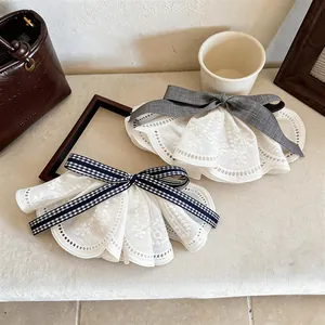 Close-up of elegant lace bow hair clips with grey and gingham ribbon accents