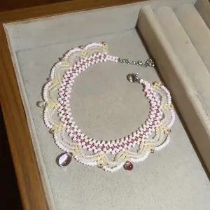 Detailed view of handmade pink beaded lace necklace with glass drop pendants.
